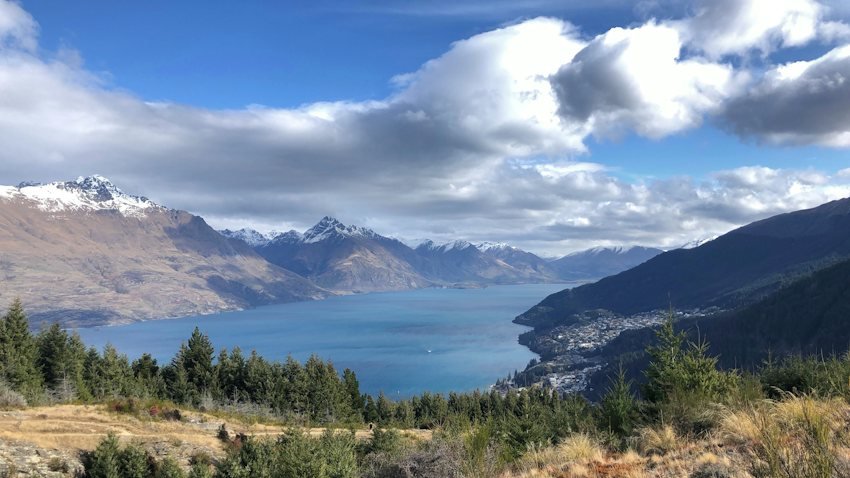 Vista elevada de Queenstown junto al lago Whakatipu, rodeado de montañas en Nueva Zelanda.